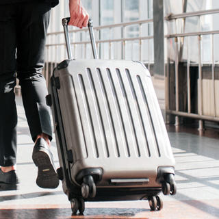 a person in a suit pulling a suitcase 