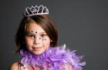 girl in purple boa, tiara, and face gems