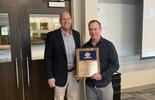Two men, one of whom is Rick Rosati, standing together. Rick holds an award 