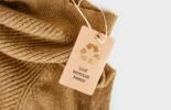 brown sweater with carboard tag that reads: 100% recycled material