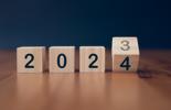 4 wooden blocks that read 2023 and the 3 is being flipped to a 4 to read 2024