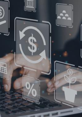 person working on computer with a variety of money and graph icons in front of the computer